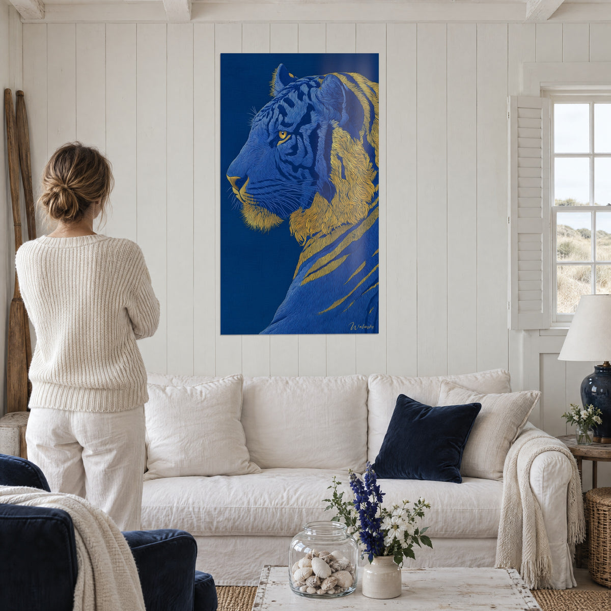 Quadro tigre di profilo in blu cobalto con criniera dorata e sguardo ambrato, sopra un divano in un soggiorno luminoso