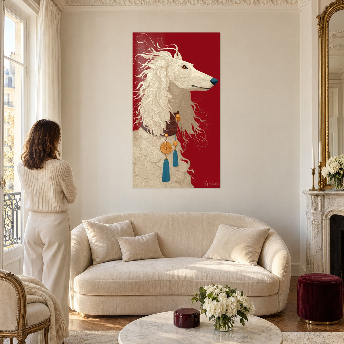 Cuadro galgo saluki color crema con melena ondulada sobre fondo rojo carmín, collar marrón y borla turquesa, encima de un sofá en un salón luminoso