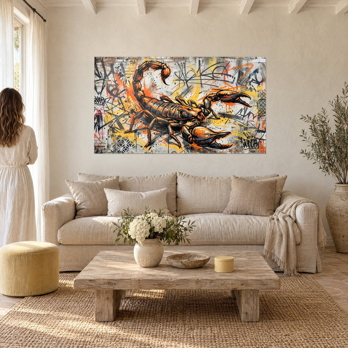 Tableau scorpion orange aux pinces dressées sur mur de graffitis jaunes et noirs, au-dessus d'un canapé dans un salon lumineux