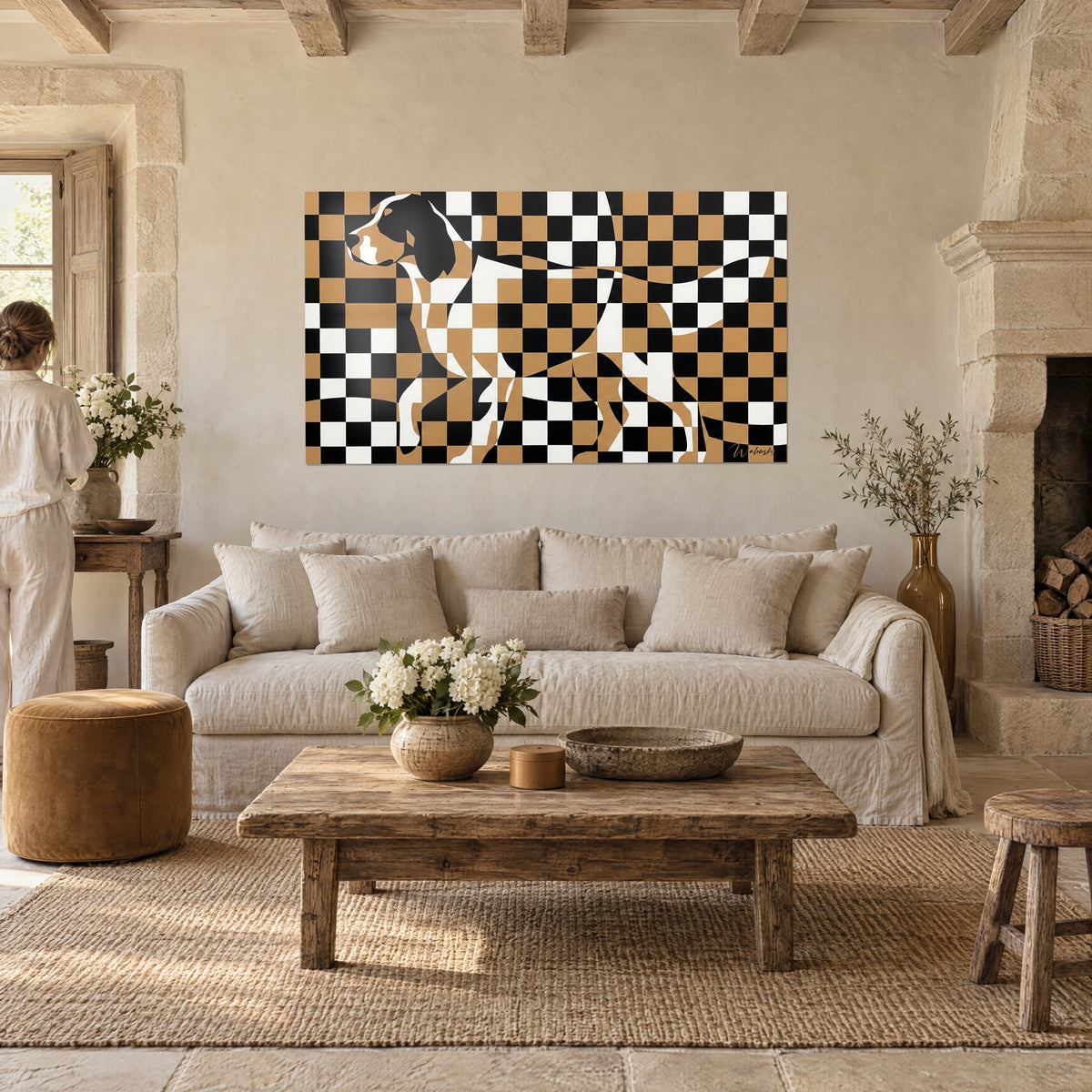 Wall art hunting dog in black, white and ochre checkerboard mosaic, two people seen from behind, above a sofa in a bright living room