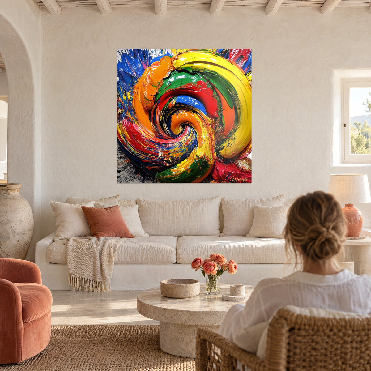 Tableau spirale multicolore en peinture épaisse, jaune et orange vifs, bleu profond, femme chignon de dos au-dessus d'un canapé dans un salon lumineux