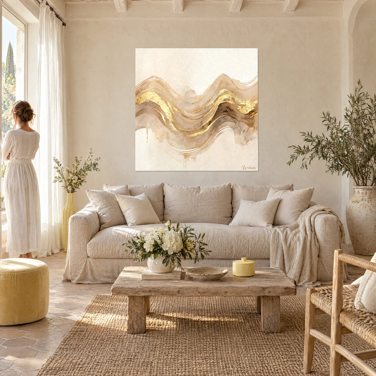 Tableau vagues sablées traversées de feuille d'or, beige et ocre, deux silhouettes de dos, au-dessus d'un canapé dans un salon lumineux
