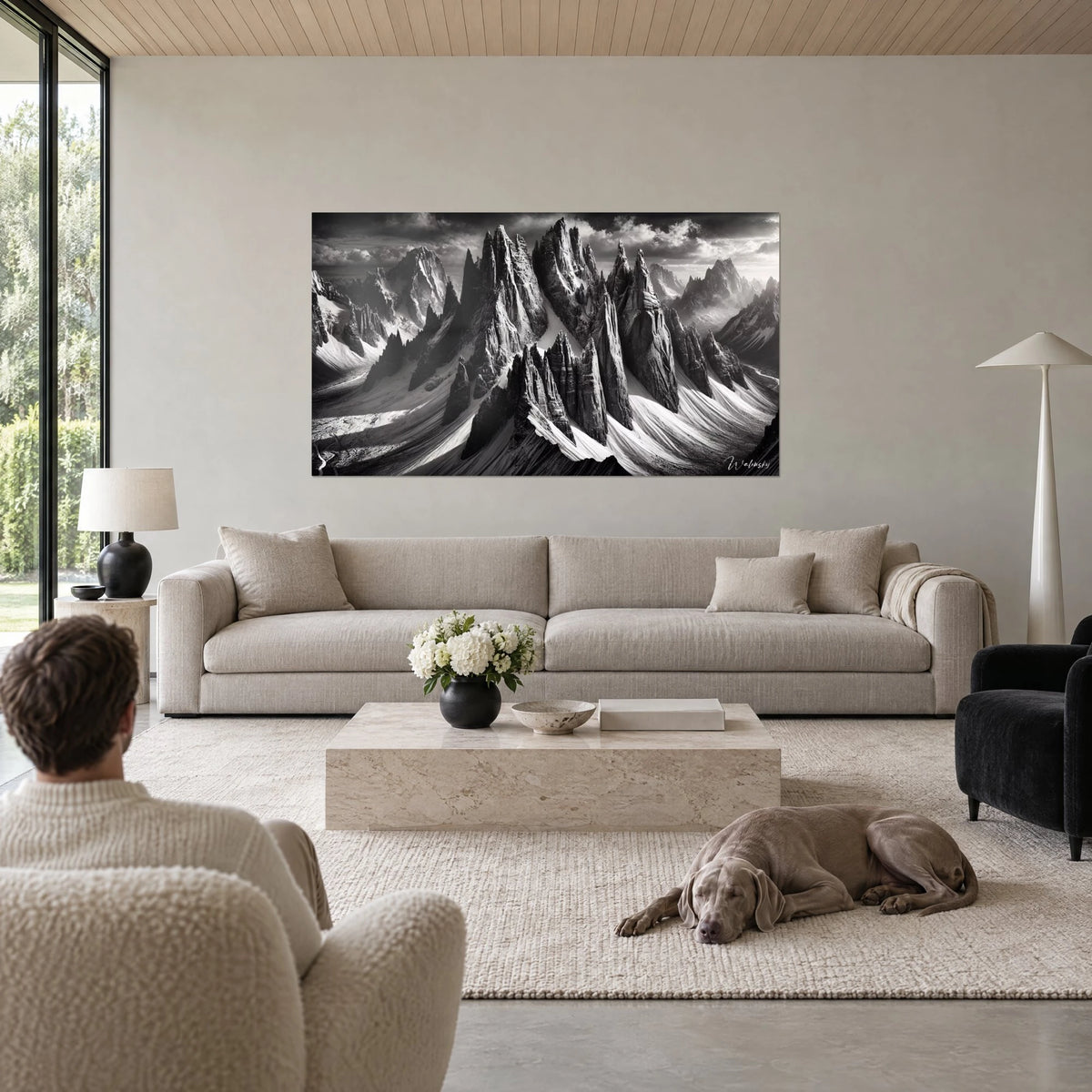 Wall art jagged peaks in black and white, dazzling snow and dark clouds, above a sofa in a bright living room