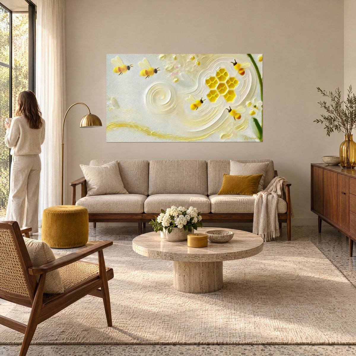 Wall art golden bees gathering nectar from a raised honeycomb, ivory background, couple seen from behind, above a sofa in a bright living room