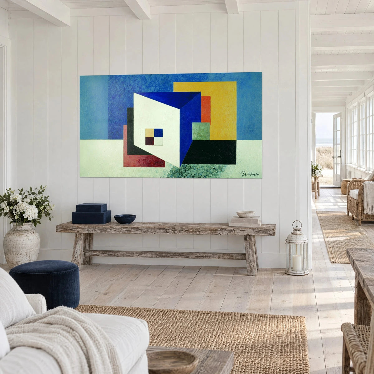 Tableau prisme ivoire aux arêtes bleu outremer, rectangles orange et noir en retrait, sur console en bois brut, maison de bord de mer