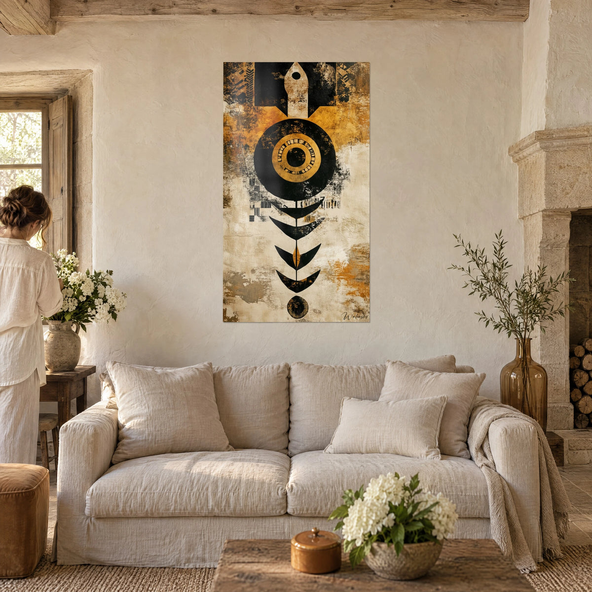 Wall art black disc rimmed in gold on ochre and cream background, beige arrow at top, above a sofa in a bright living room