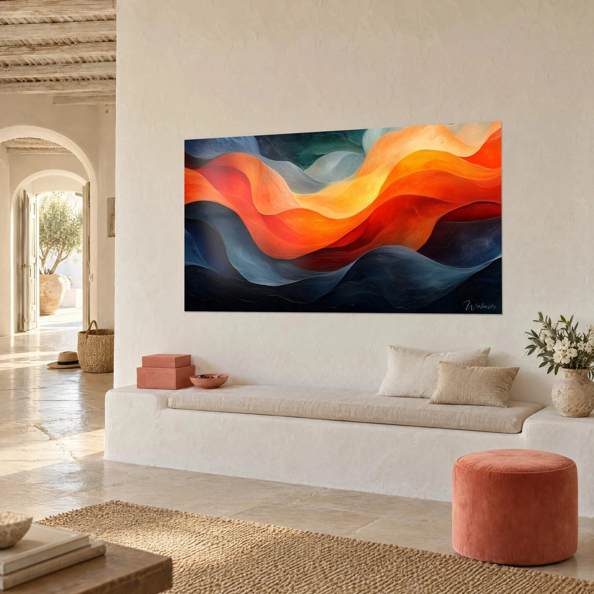 Tableau ondulations abstraites orange vif et bleu acier, accroché sur un mur crépi, banquette blanche et pouf corail, vue de trois-quarts