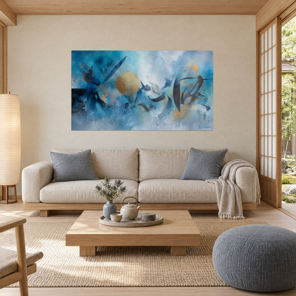 Tableau disque doré cerné de bleu turquoise et de traits calligraphiques noirs, au-dessus d'un canapé dans un salon lumineux