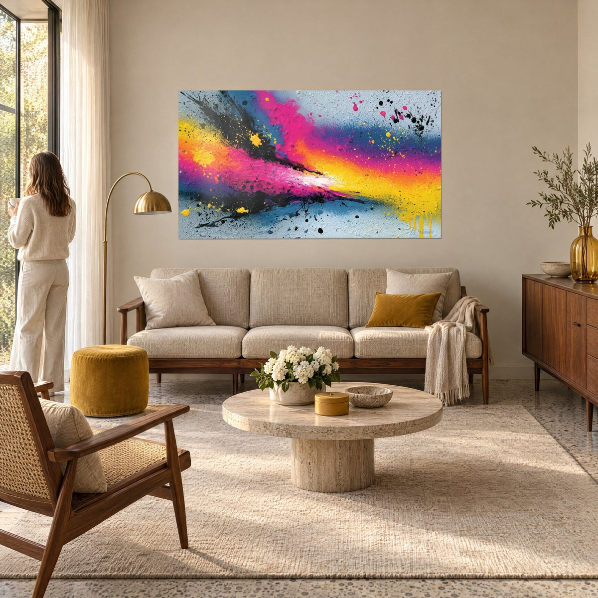 Tableau explosion de peinture rose fuchsia et jaune citron lacérée de noir, éclaboussures, au-dessus d'un canapé dans un salon lumineux