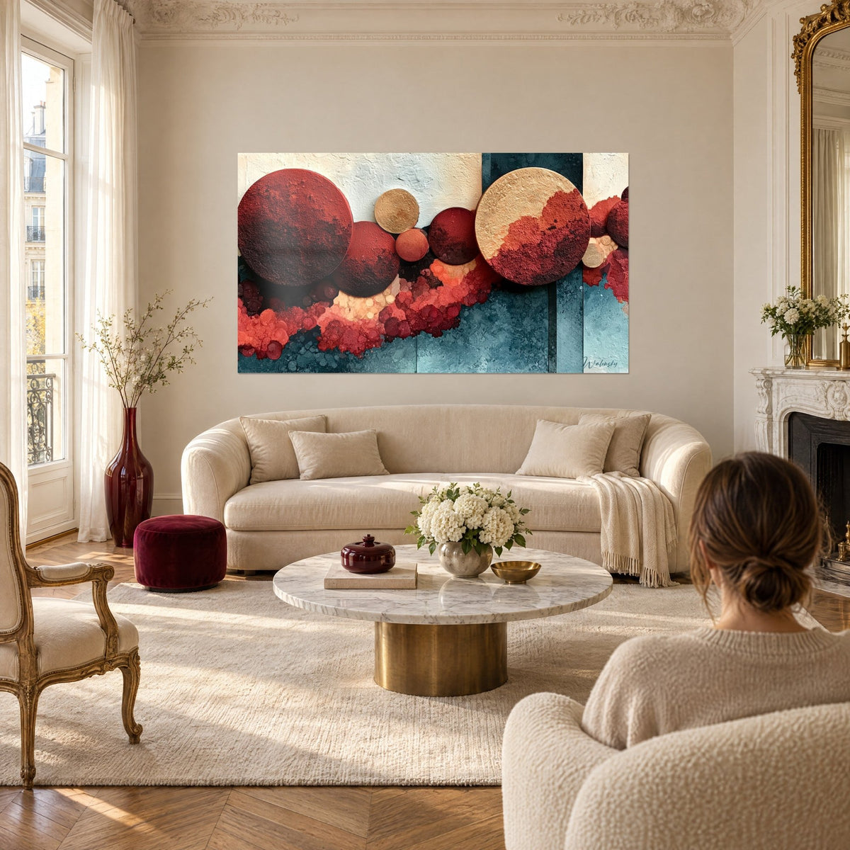 Wall art mineral discs in terracotta and petrol blue, two women seen from behind, above a sofa in a bright living room