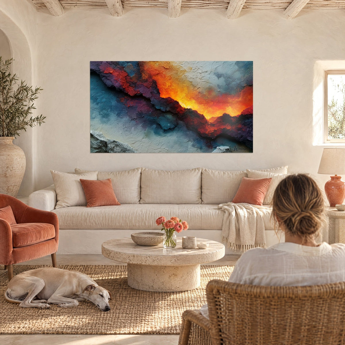 Tableau faille incandescente orange et jaune sur fond bleu givré, regardée par une femme, au-dessus d'un canapé dans un salon lumineux