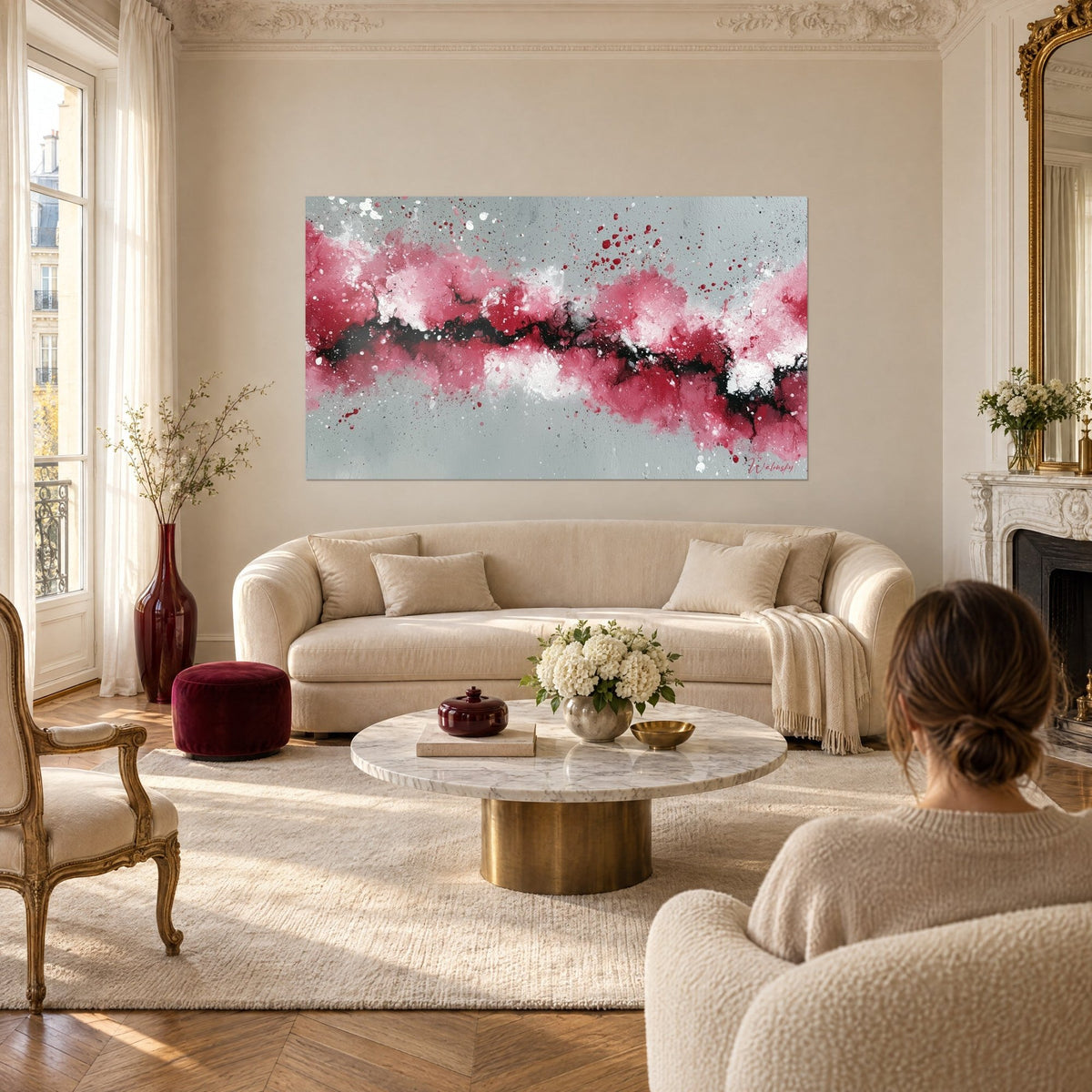 Quadro con una sinuosa faglia nera tra nuvole rosa lampone e bianche su sfondo grigio, sopra un divano in un soggiorno luminoso