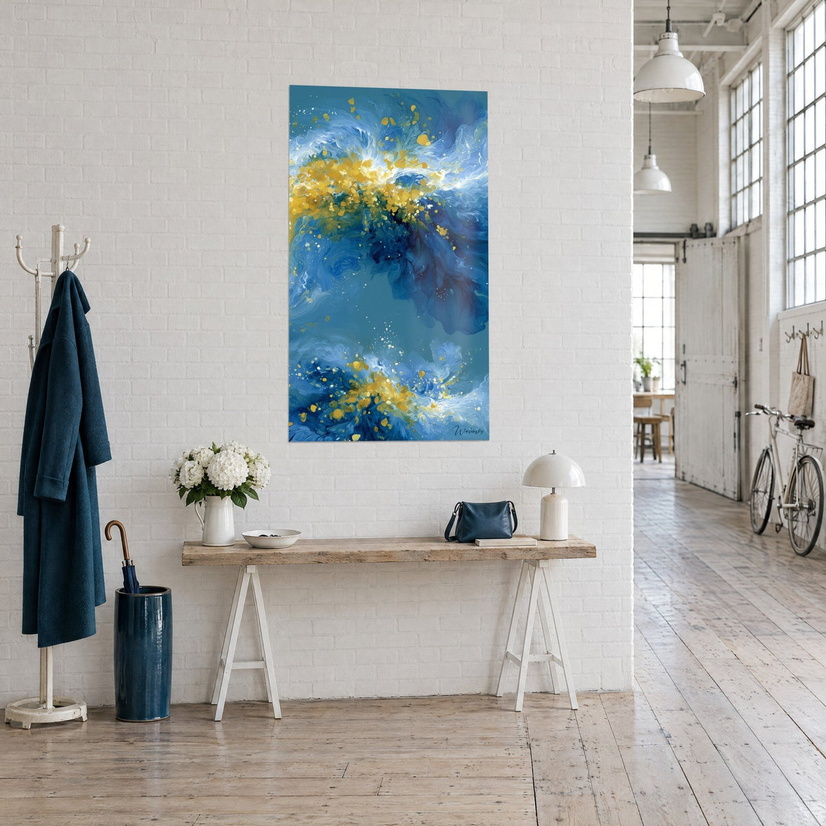 Tableau écume céleste, tourbillons indigo et jaune safran éclaboussés de blanc, sur un mur de briques blanches du loft
