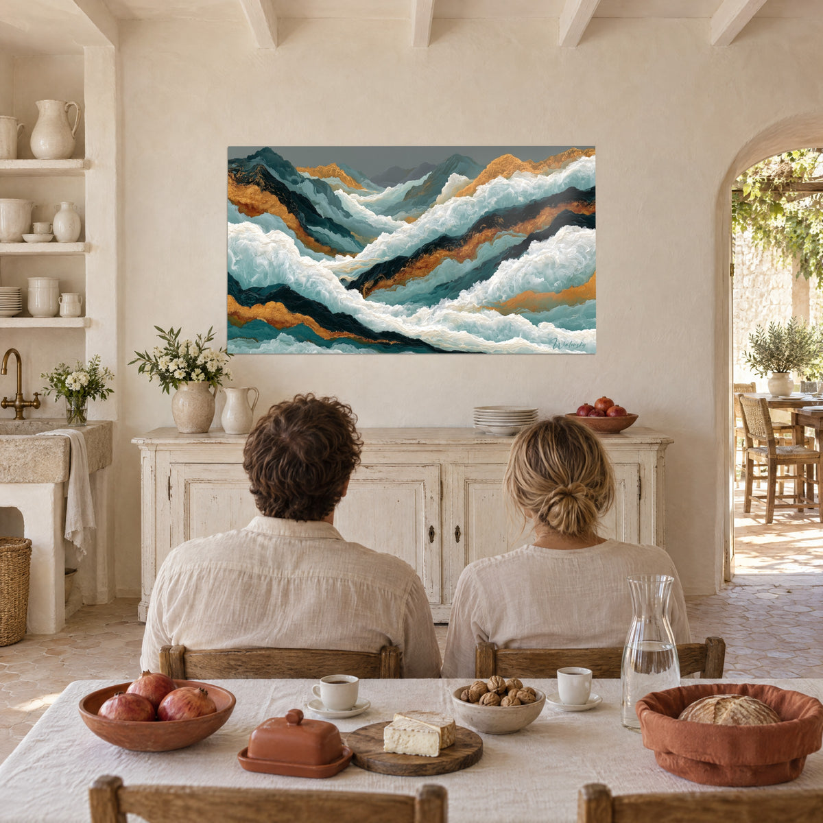 Schilderij van blauwgroene zeebergen en koperkleurig goud, een stel van achteren aan tafel, Provençaalse boerderij met crèmekleurige muren en wit dressoir