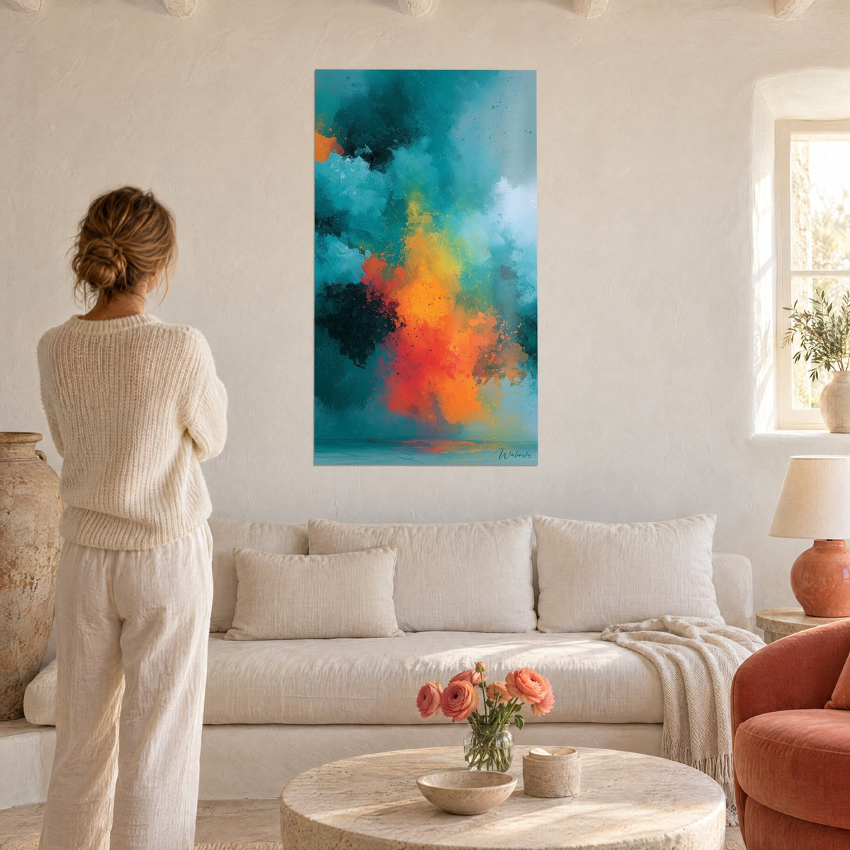 Wall art turquoise thunderstorm cloud blazing with orange and red, woman seen from behind above a sofa in a bright living room