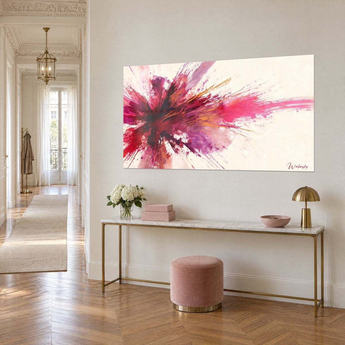 Tableau gerbe de peinture magenta et violine jaillissant sur fond crème, vue en biais, au-dessus d'une console dorée dans l'entrée