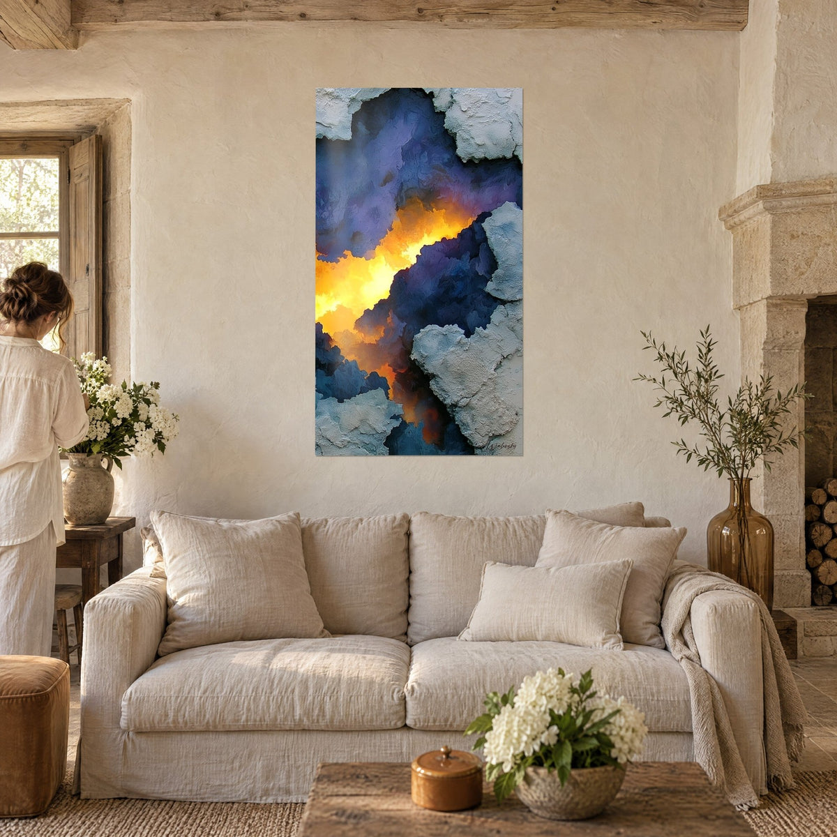 Tableau crevasse rocheuse aux lueurs d'or et de safran, roche bleu nuit, deux personnes de dos, au-dessus d'un canapé dans un salon lumineux
