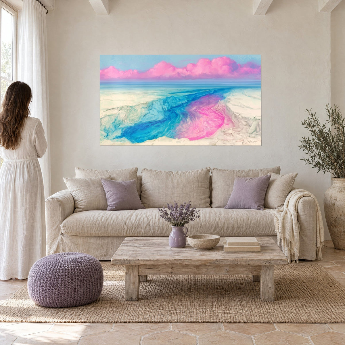 Schilderij van een gebarsten ijskloof, turquoise en fuchsia rivier onder roze wolken, vrouw van achteren boven een bank in een lichte woonkamer