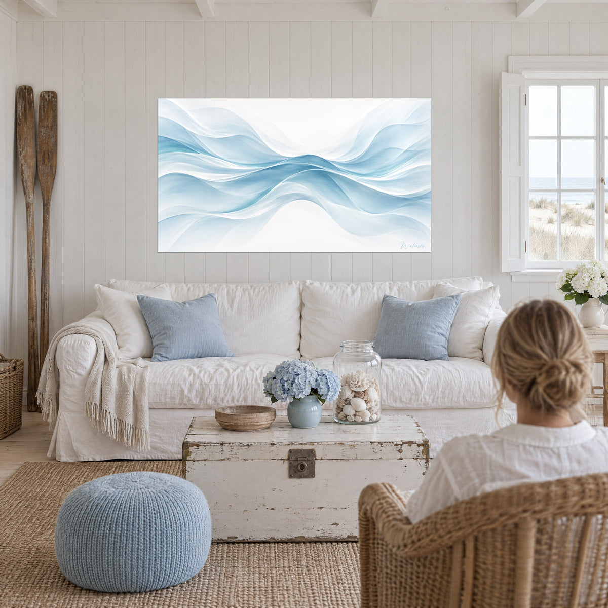 Gemälde mit durchscheinenden Wellen in Himmelblau und Weiß, dichte Mulde in der Mitte, von hinten betrachtet über einem Sofa in einem hellen Wohnzimmer