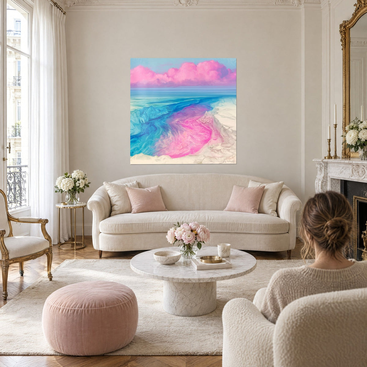 Tableau rivage turquoise et rose fuchsia, nuages roses sur ciel bleu pâle, au-dessus d'un canapé dans un salon lumineux