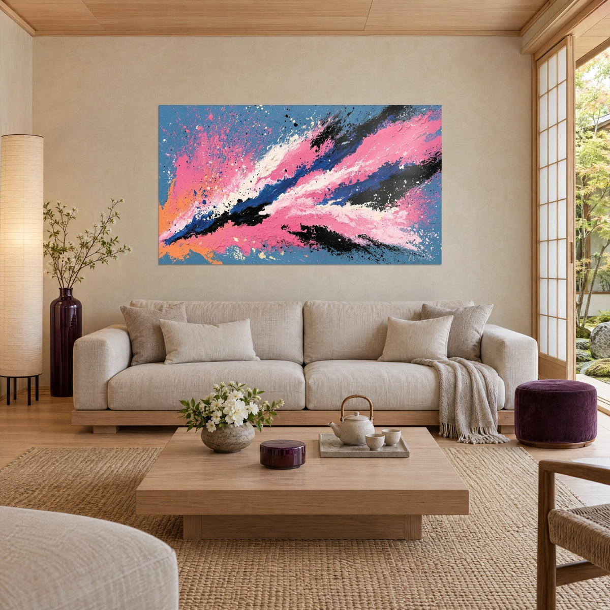 Wall art explosive pink and blue diagonal, black streaks and splatters, hanging above a sofa in a bright living room