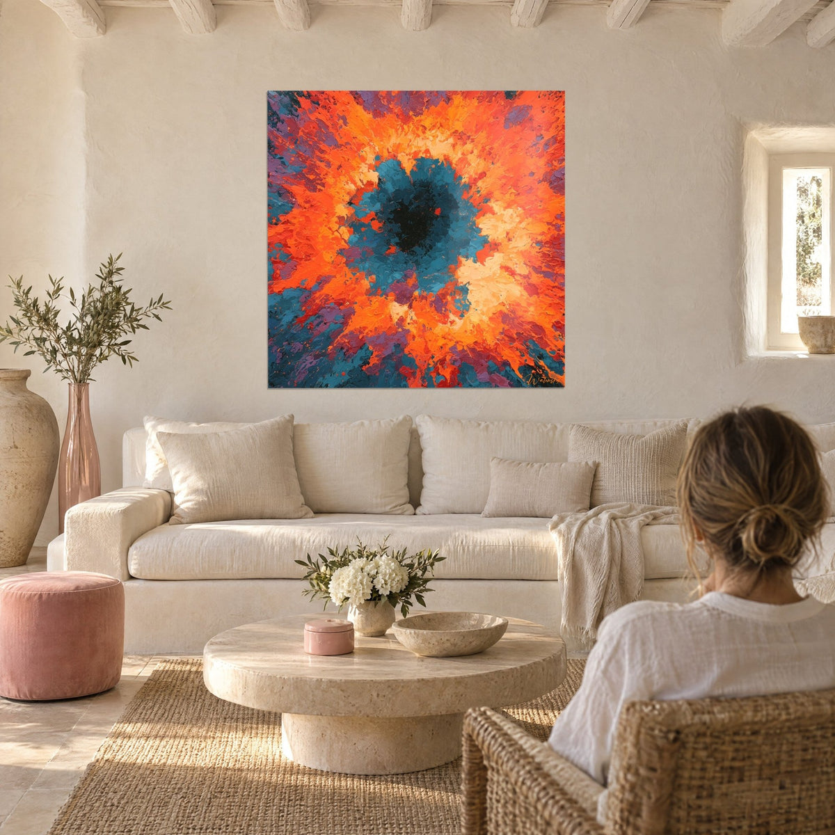 Wall art blazing vortex with a black and teal core, bright orange flares, woman seen from behind above a sofa in a bright living room