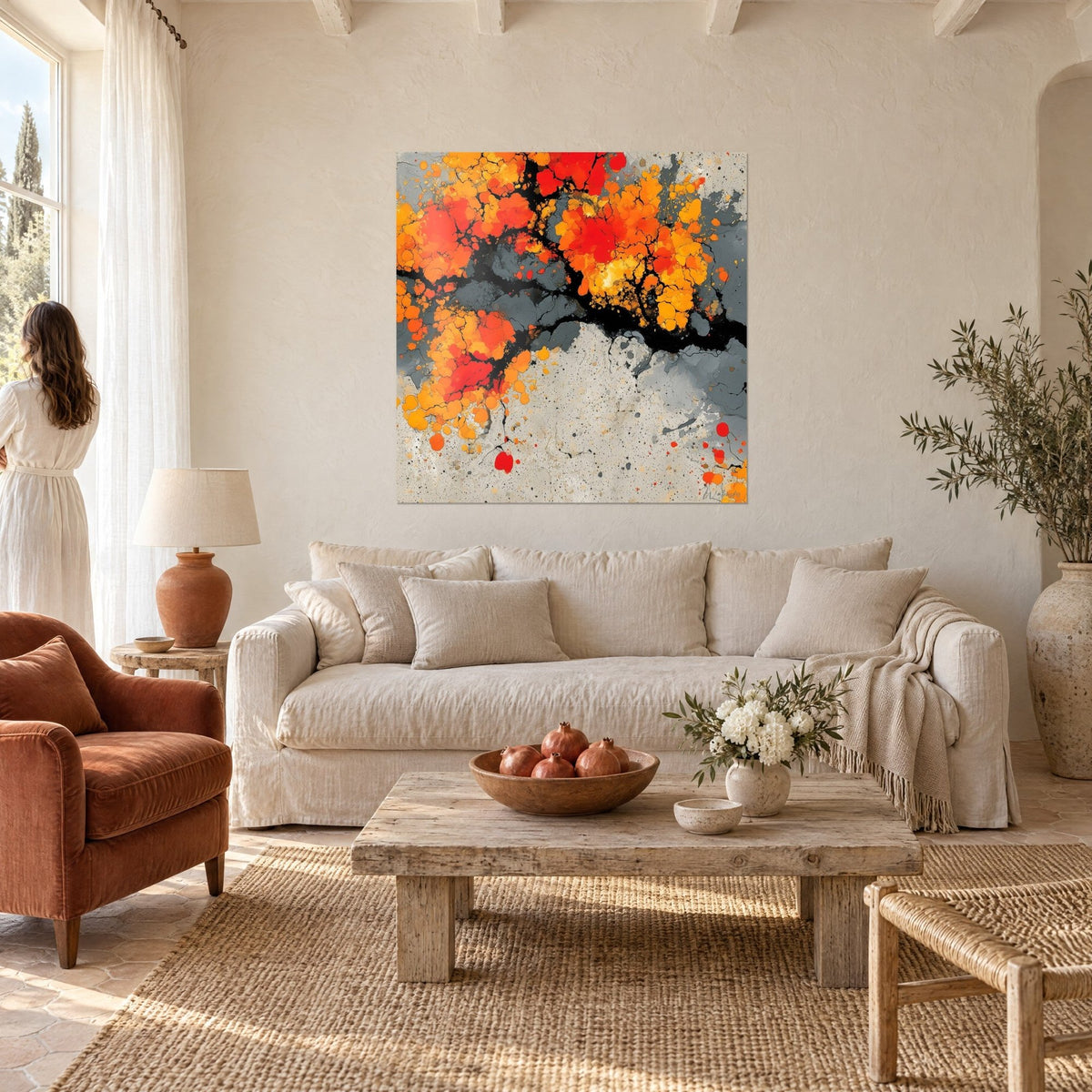 Quadro fioritura fiammeggiante arancio e rosso su fondo grigio, mani viste di spalle lo guardano sopra un divano in un soggiorno luminoso