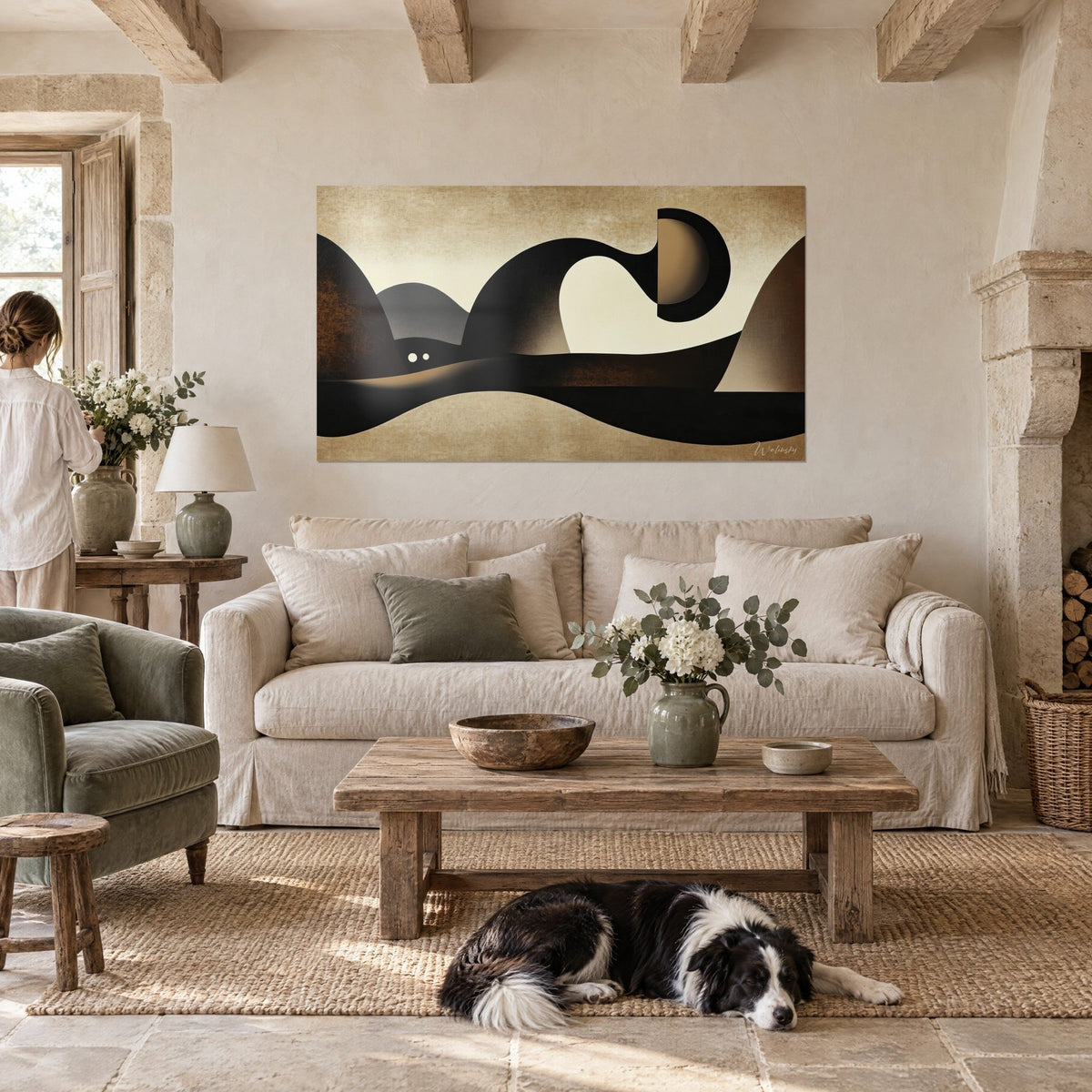 Wall art with sculptural black waves on cream and sand background, two white eyes beneath a hill, above a sofa in a bright living room