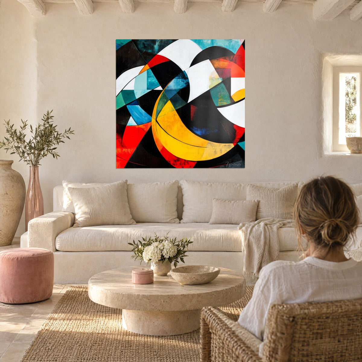 Wall art with yellow sunburst and bright red geometric arcs, black and turquoise facets, above a sofa in a bright living room