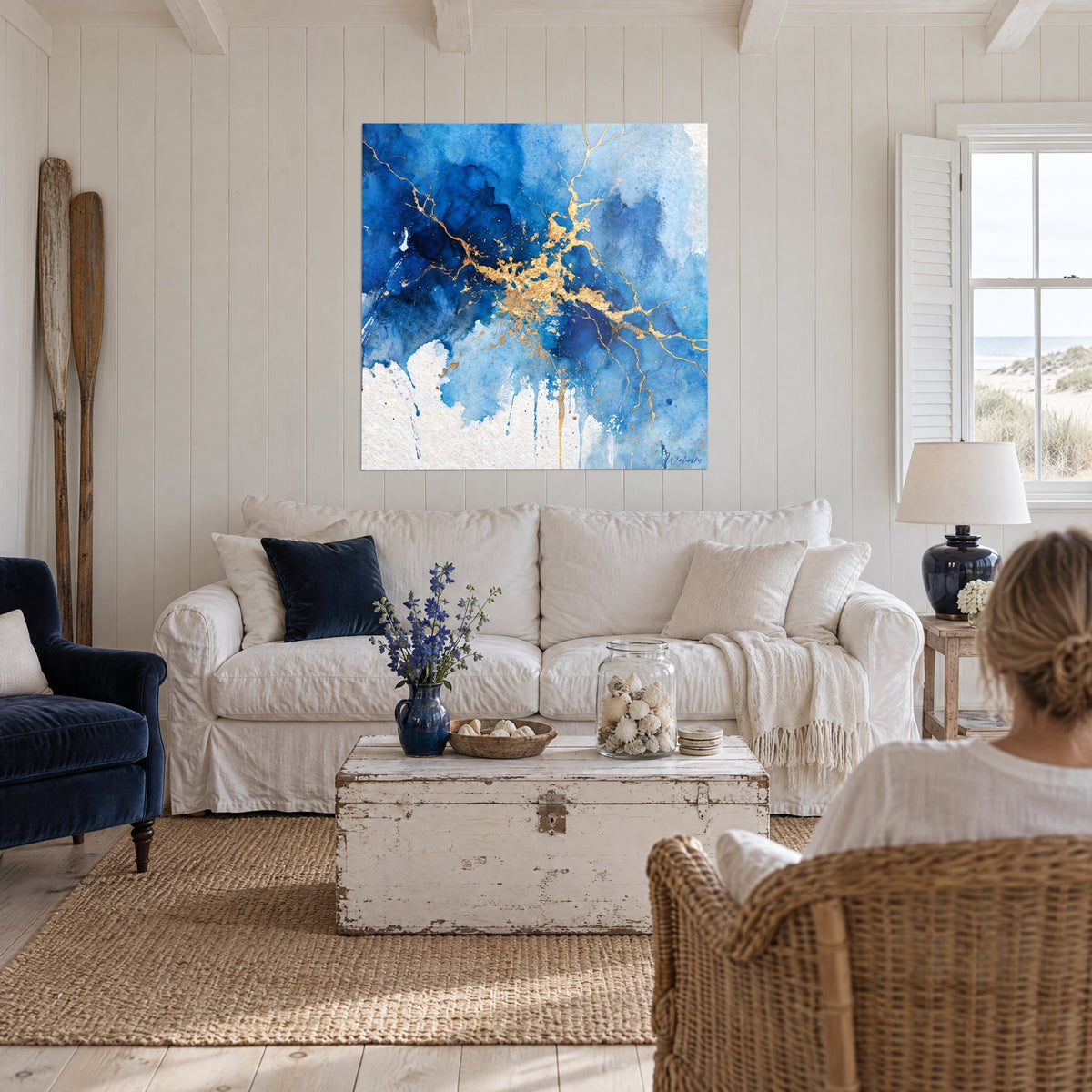 Tableau éclair doré zébrant un nuage bleu cobalt et blanc, deux personnes de dos au-dessus d'un canapé dans un salon lumineux