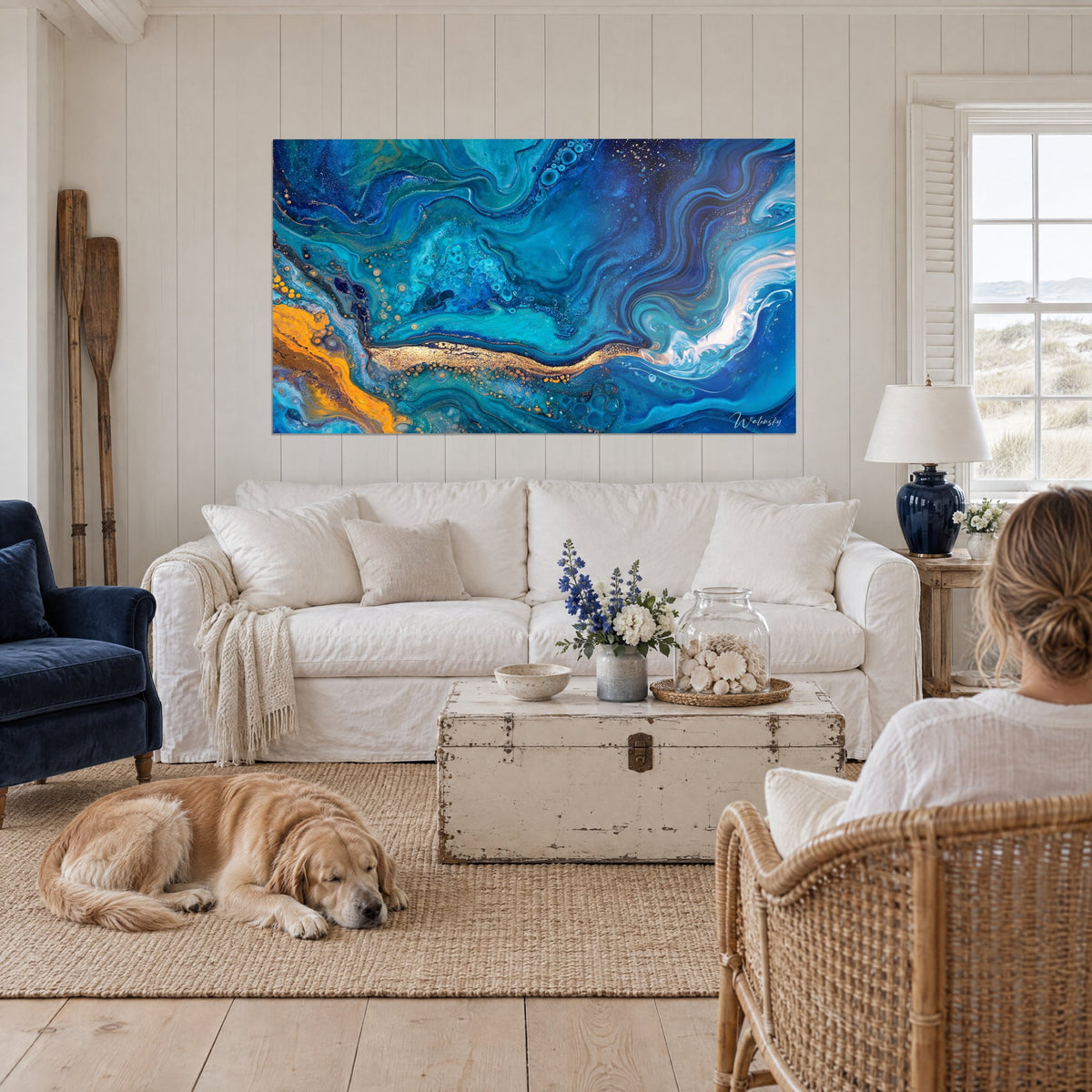 Tableau marbrure fluide bleu cobalt et turquoise, veine dorée en son centre, au-dessus d'un canapé dans un salon lumineux