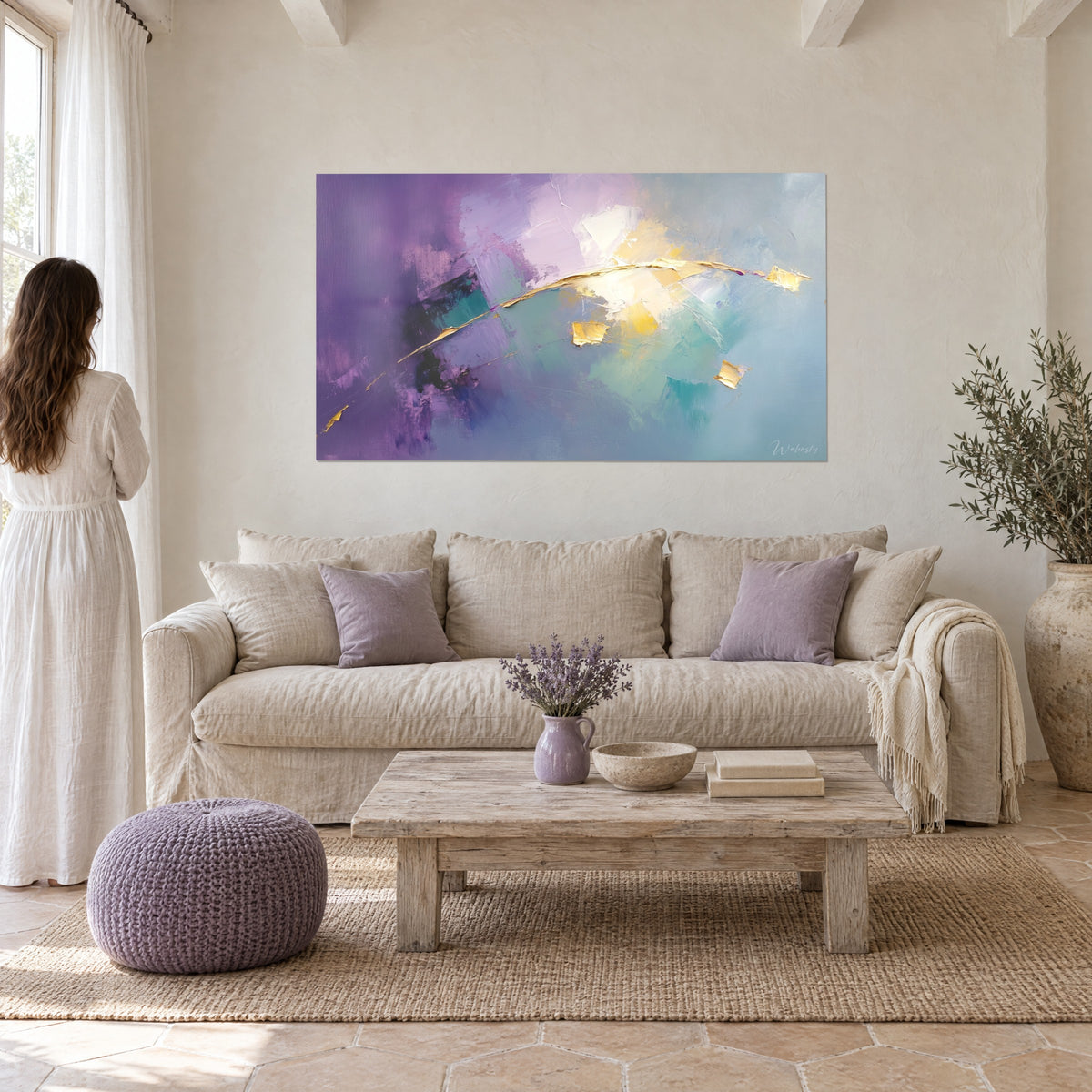 Schilderij Gouden boog die lavendelkleurige en turquoise velden doorsnijdt, vrouw van achteren, boven een bank in een lichte woonkamer
