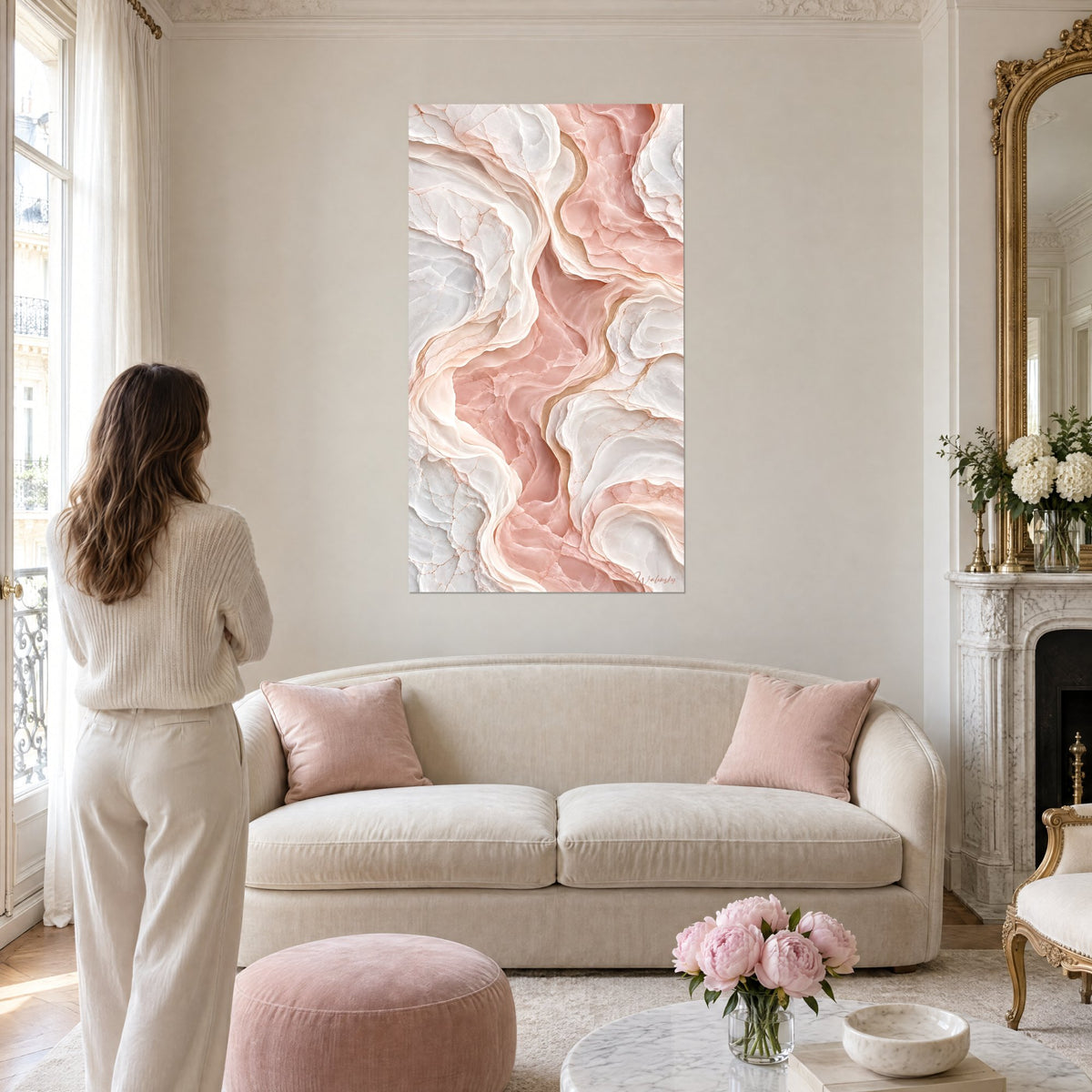 Tableau strates de marbre rose poudré et blanc nacré aux veines dorées, une femme de dos, au-dessus d'un canapé dans un salon lumineux
