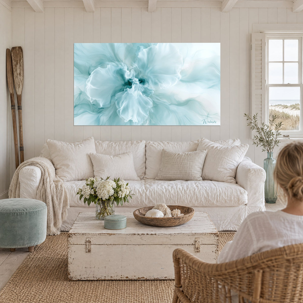 Tableau orchidée bleu pastel aux pétales de voile, cœur turquoise, canapé blanc, lampe en rotin au-dessus d'un canapé dans un salon lumineux