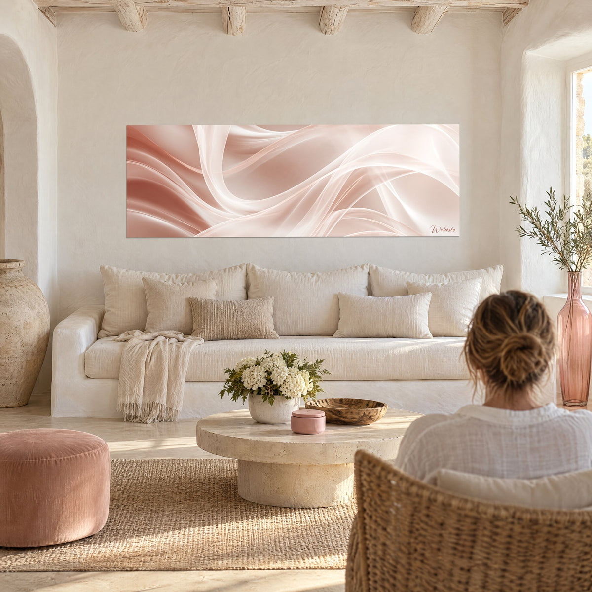 Tableau voiles satinés rose poudré et blanc en torsade, panoramique, au-dessus d'un canapé dans un salon lumineux