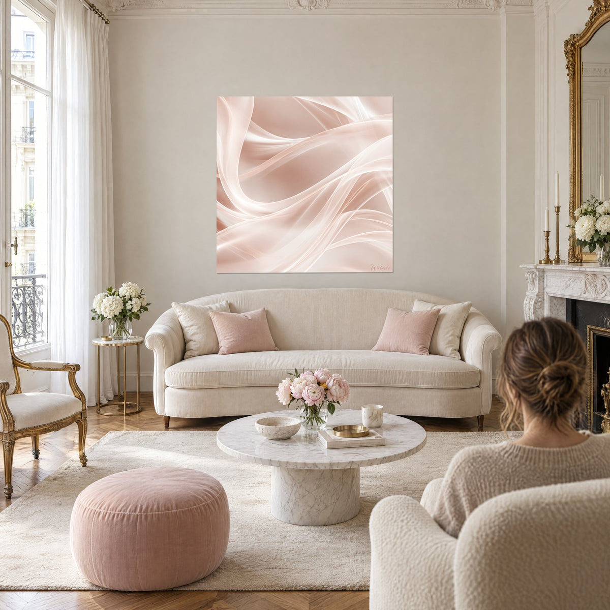 Tableau voiles de soie saumon et ivoire aux rubans croisés, une femme de dos, au-dessus d'un canapé dans un salon lumineux
