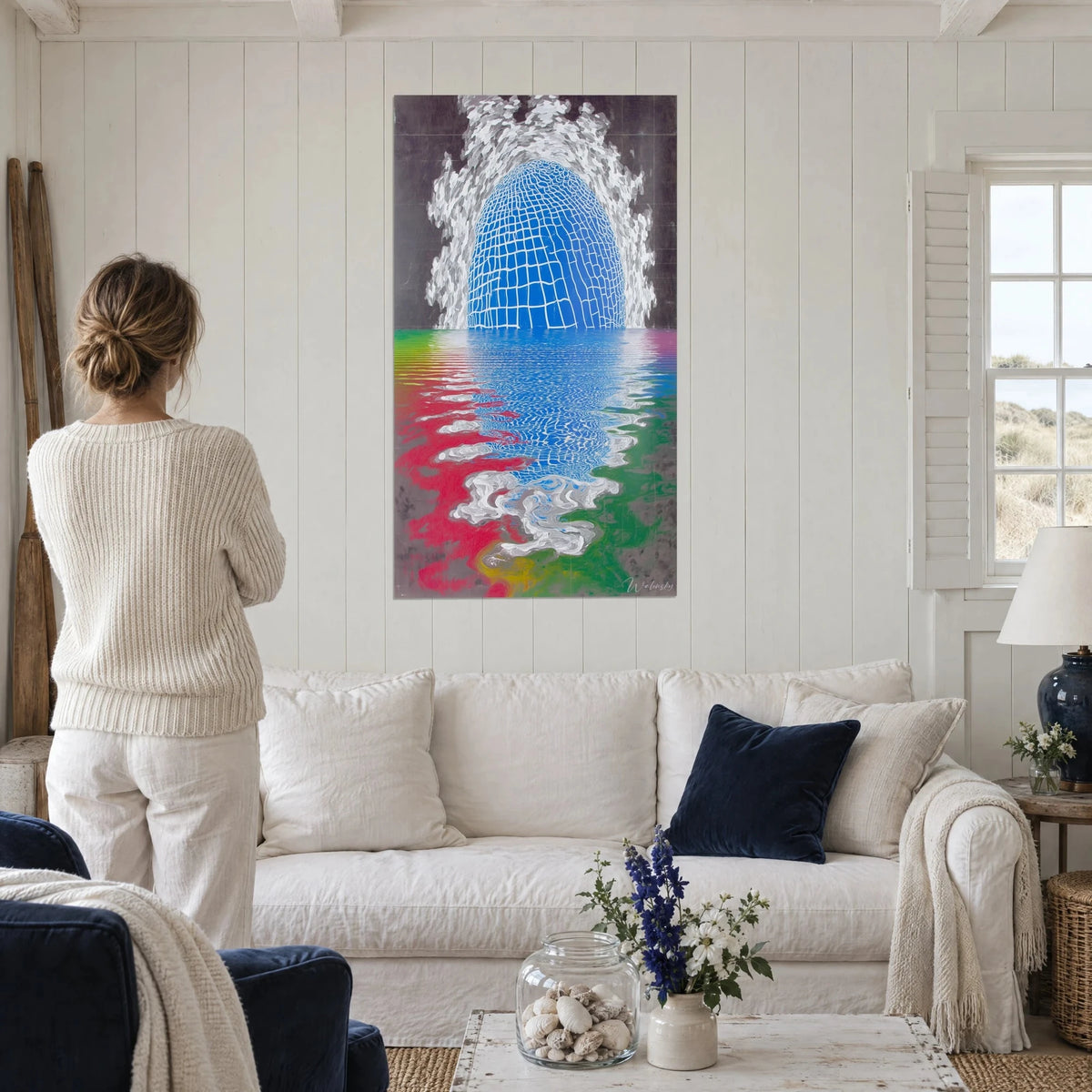 Quadro cupola blu a quadretti riflessa in onde rosse e verdi, donna di spalle, sopra un divano in un soggiorno luminoso