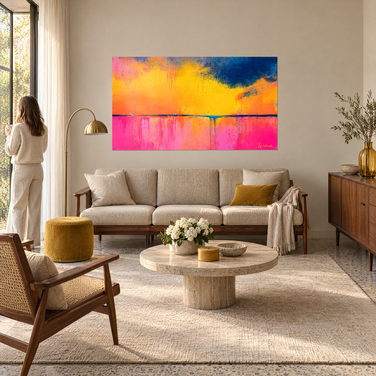 Tableau horizon abstrait aux nuages jaune moutarde et bleu nuit sur bandeau rose, au-dessus d'un canapé dans un salon lumineux