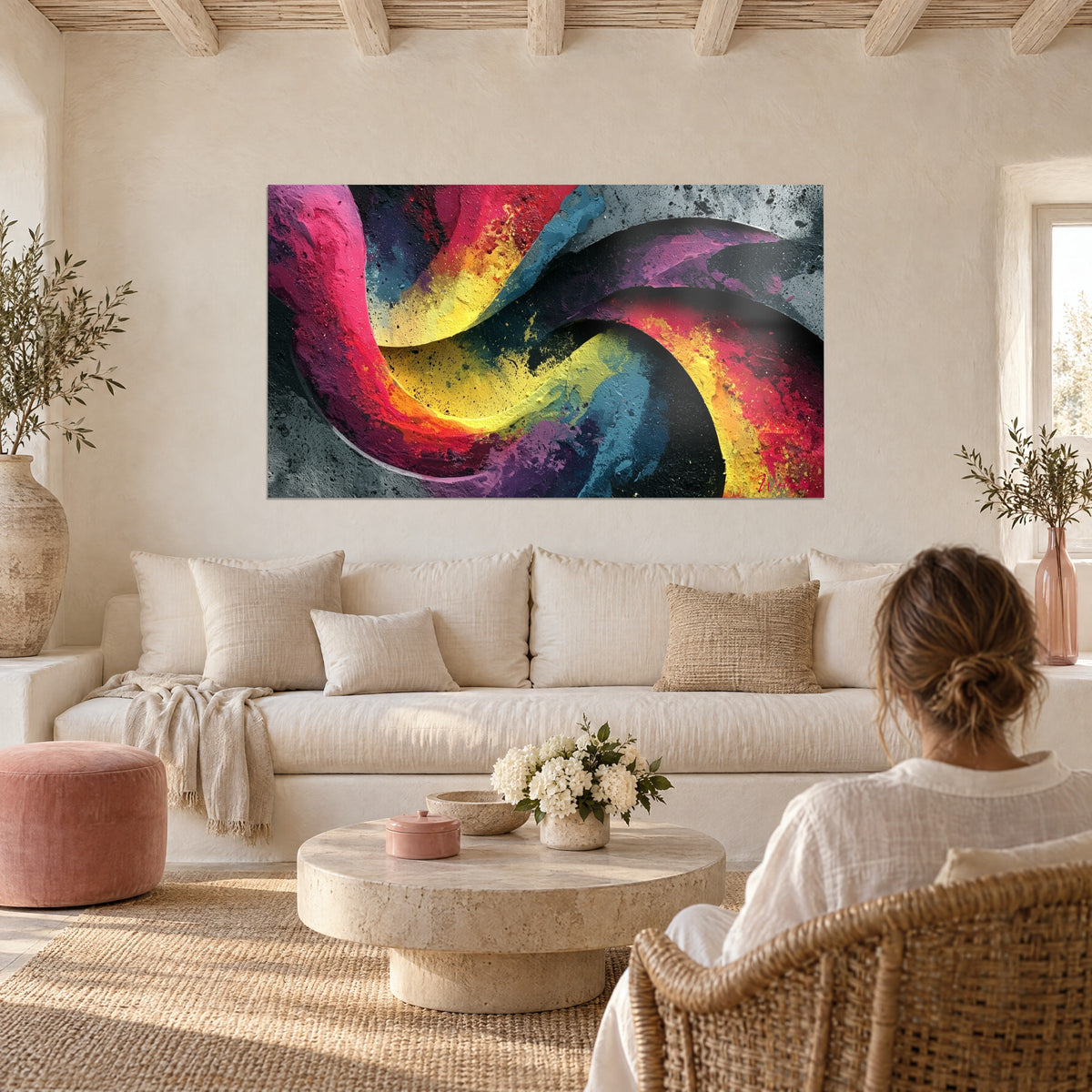 Tableau spirale rose et jaune aux reliefs de peinture épaisse sur fond gris, vu par une femme, au-dessus d'un canapé dans un salon lumineux