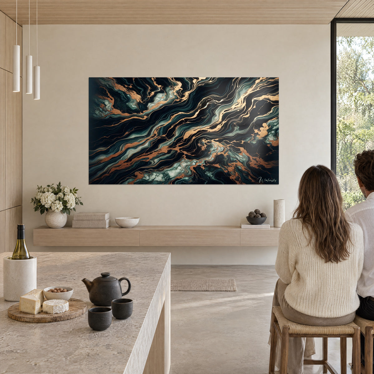 Wall art with layers of black stone streaked with copper gilding and greened white, two people seen from behind, open kitchen and stone island
