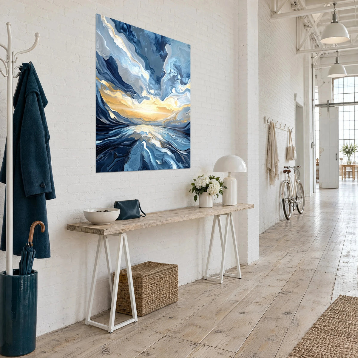Wall art of an ocean in waves of night-blue and cream-white paint, amber horizon, seen three-quarter view near a wooden console