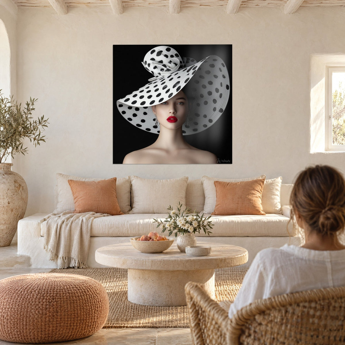 Tableau capeline immense blanche à pois noirs, lèvres rouges sur fond noir, deux personnes de dos au-dessus d'un canapé dans un salon lumineux