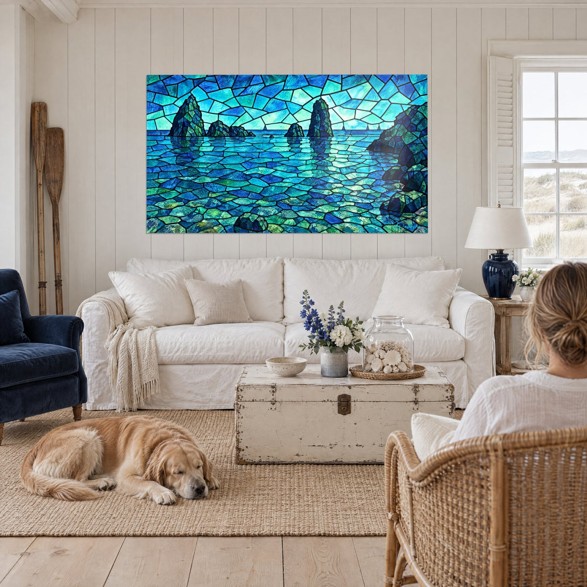 Tableau récifs rocheux en vitrail turquoise et bleu cobalt, trois voiliers à l'horizon, au-dessus d'un canapé dans un salon lumineux