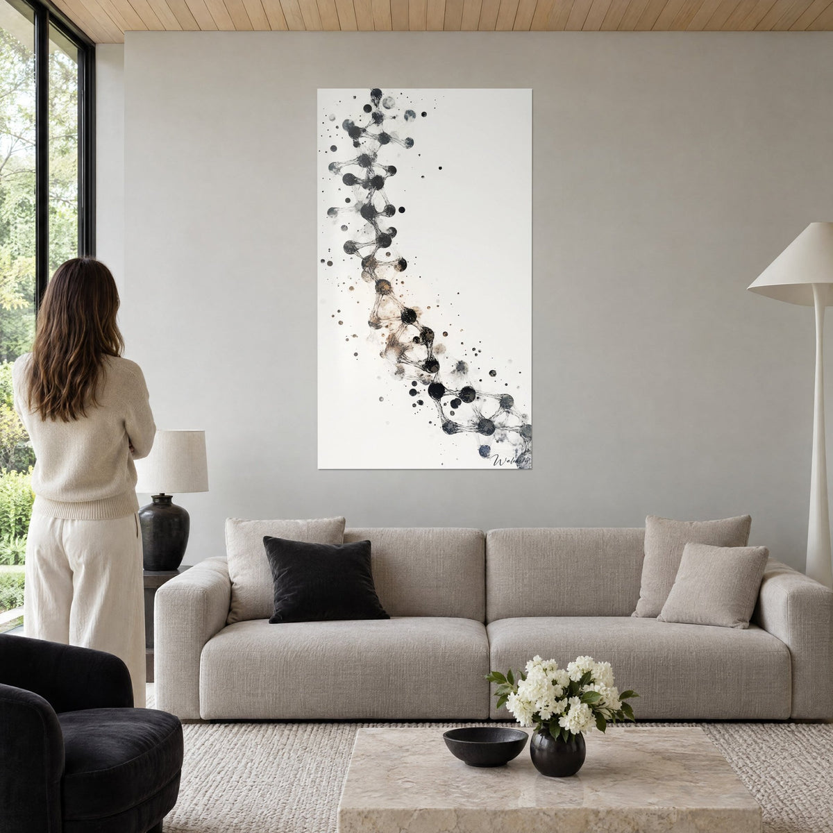 Tableau hélice ADN en sphères noires reliées par des fils gris sur fond ivoire, au-dessus d'un canapé dans un salon lumineux