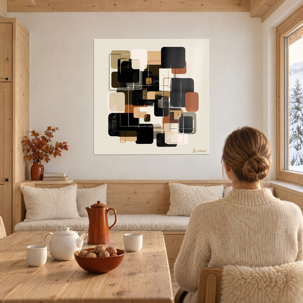 Tableau puzzle de blocs arrondis noirs, bruns et crème sur fond ivoire, mur blanc d'un coin repas en chalet