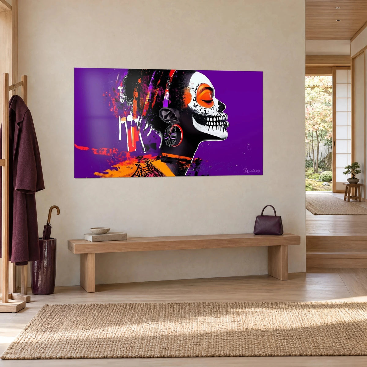 Tableau visage de squelette peint, orange vif sur fond violet, accroché au mur beige d'une entrée japandi, banc en bois sous l'œuvre