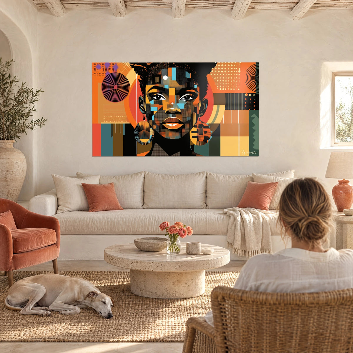 Cuadro retrato africano en planos cubistas naranja y turquesa, pendientes redondos, sobre un sofá en un salón luminoso