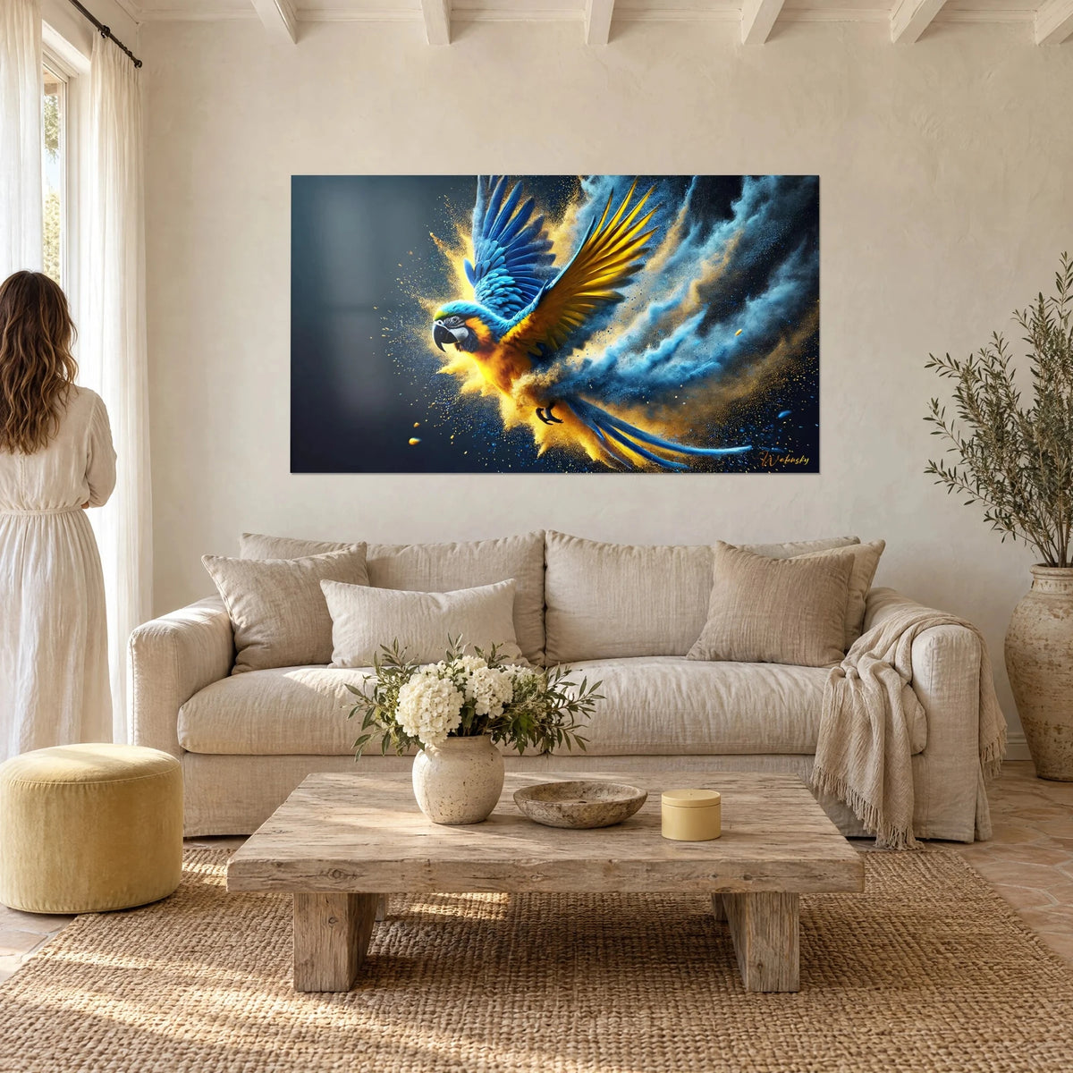 Tableau ara bleu et jaune ailes déployées dans un nuage de poudre dorée, fond nuit, au-dessus d'un canapé dans un salon lumineux