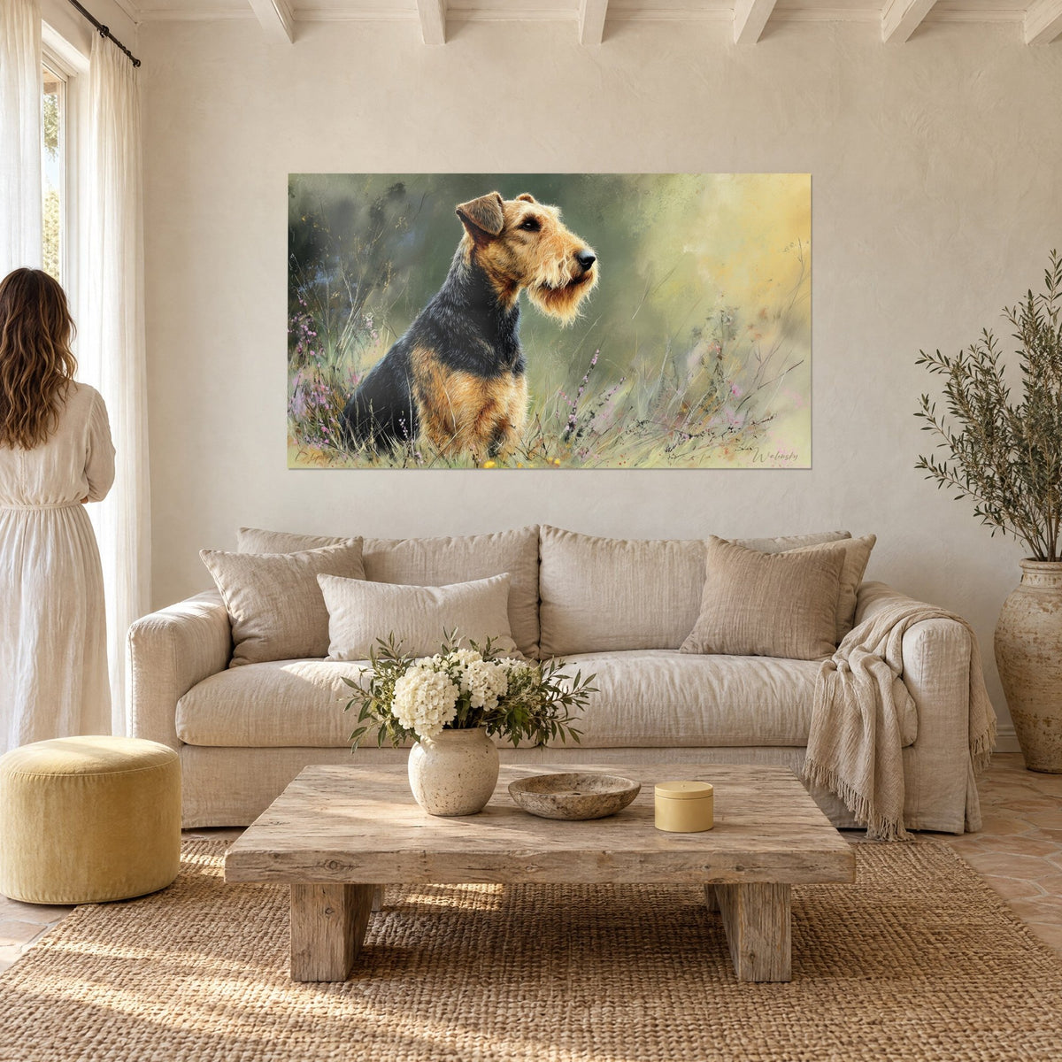 Wall art Airedale terrier with tan and black coat, muzzle raised in a flowered meadow, above a sofa in a bright living room