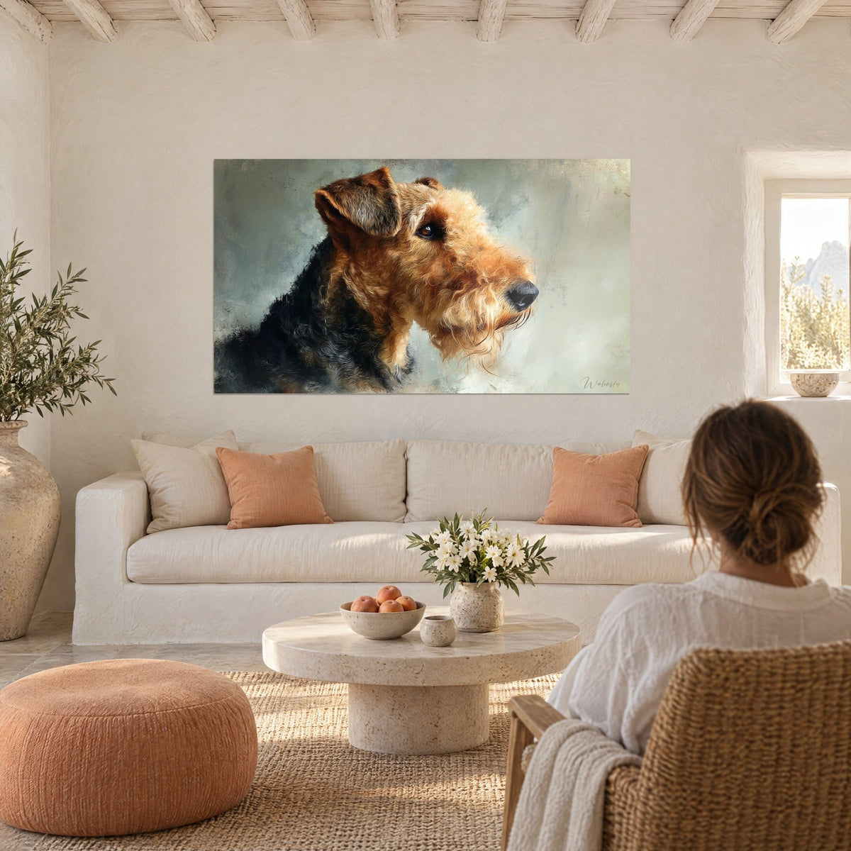 Schilderij Airedale terriër in profiel, vacht vosrood en zwart, amberkleurige blik, een vrouw van achteren, boven een bank in een lichte woonkamer